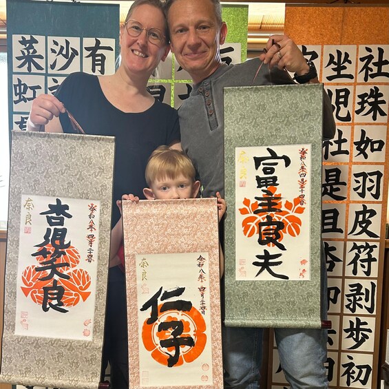 Trois personnes tenant des rouleaux de calligraphie ornés de caractères chinois. 4