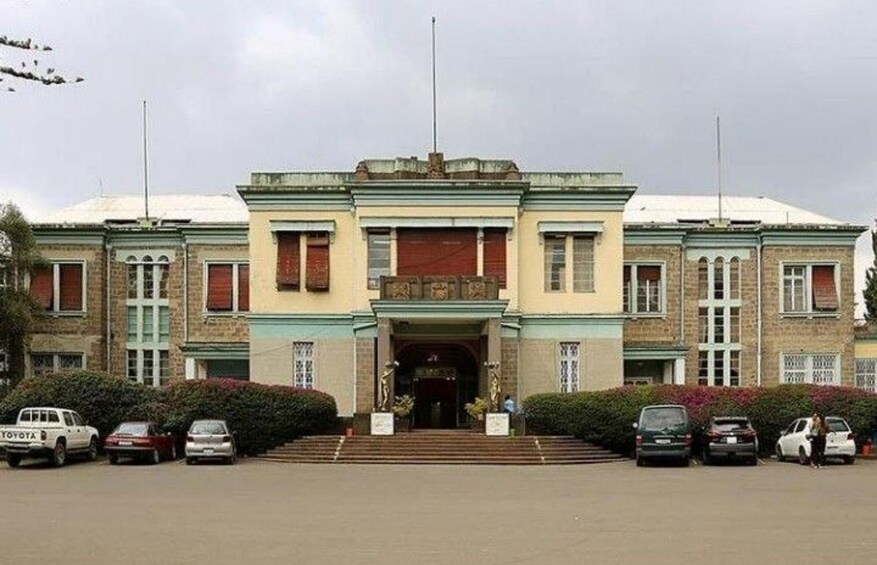 A large, historic building with a symmetrical facade, multiple windows, and a central entrance. 2