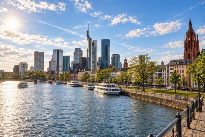A river with boats, a city skyline with modern and historic buildings, and a clear sky. 5