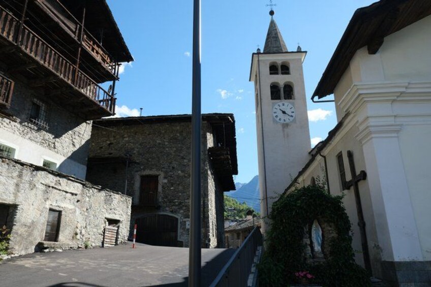 A street with old buildings, a clock tower, and a mountain in the background. 2