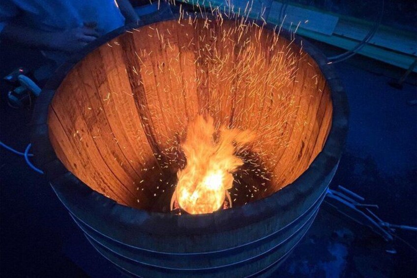 A fire burning inside a large, circular, wooden structure. 2