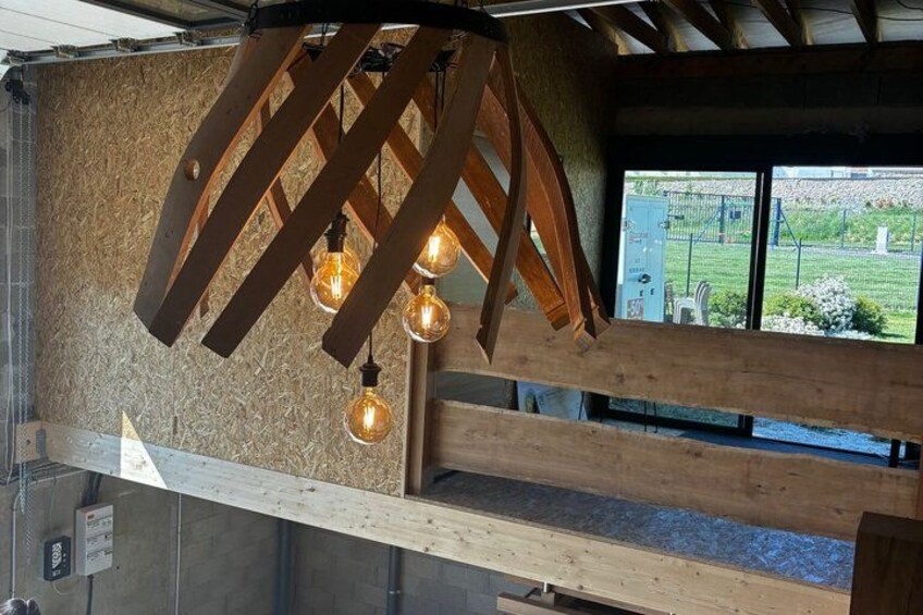 A wooden ceiling structure with exposed beams and hanging light bulbs. 5