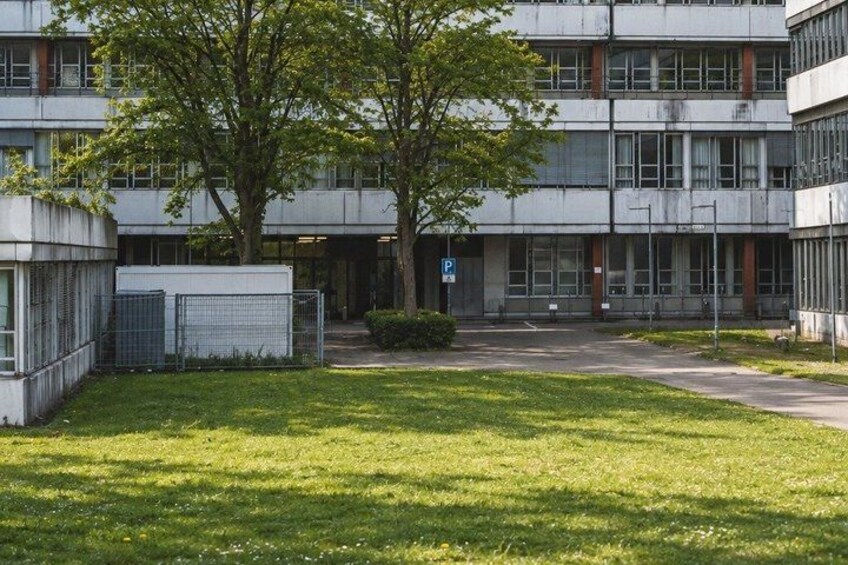 A modern building with a parking lot and a grassy area with trees. 2
