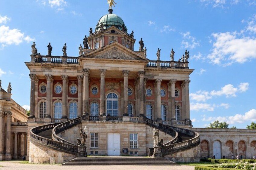 A grand building with a dome, columns, and statues. 4