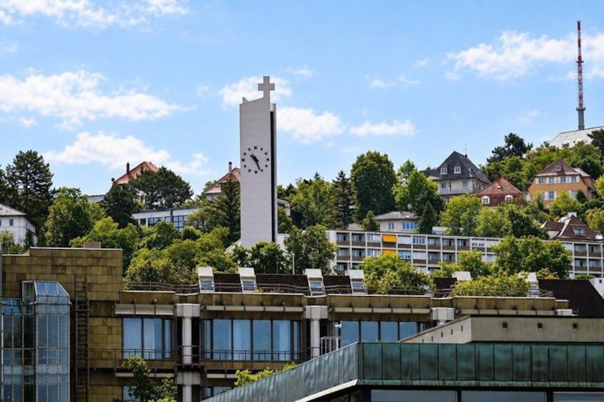A clock tower, modern buildings, and residential houses under a clear sky. 3