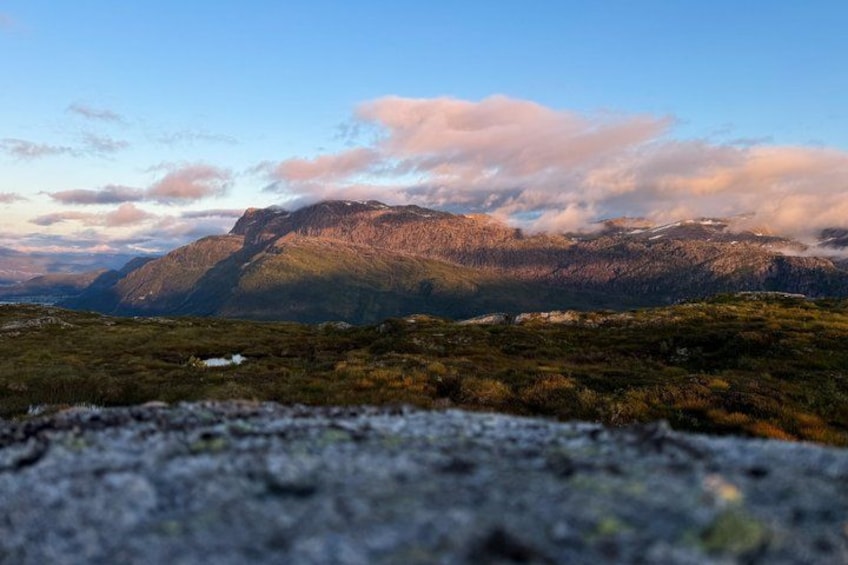 A mountainous landscape with a foreground of rocky terrain and a background of hills under a clear sky. 5