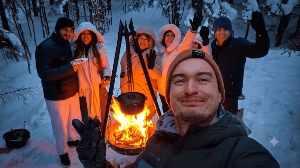 Un grupo de personas alrededor de una fogata en un bosque nevado. 2