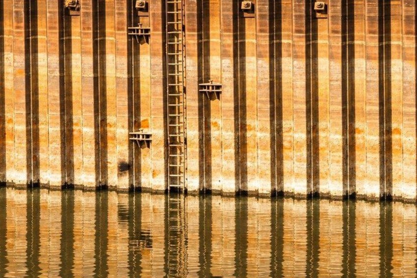 A brick wall with vertical lines and a ladder. 5