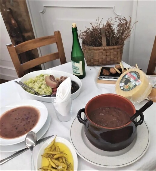 A table with various dishes, a bottle of champagne, and a basket of dried plants. 3