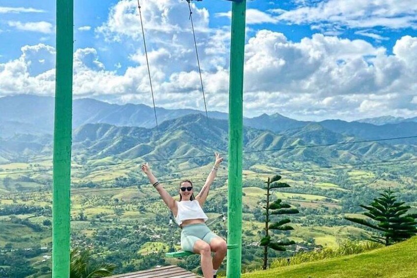A person on a swing with a mountainous landscape in the background. 4