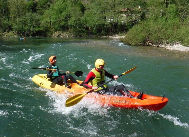 Two people kayaking on a river surrounded by greenery. 5