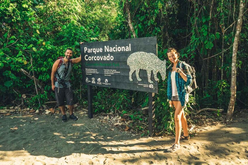 To personer står foran en skilt for Parque Nacional Corcovado. 1