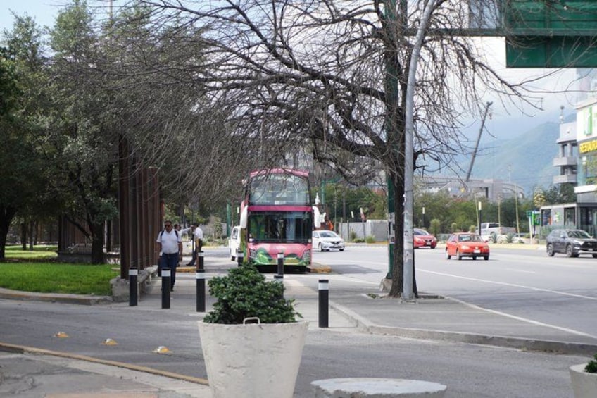 A red bus on a city street with pedestrians and cars. 2