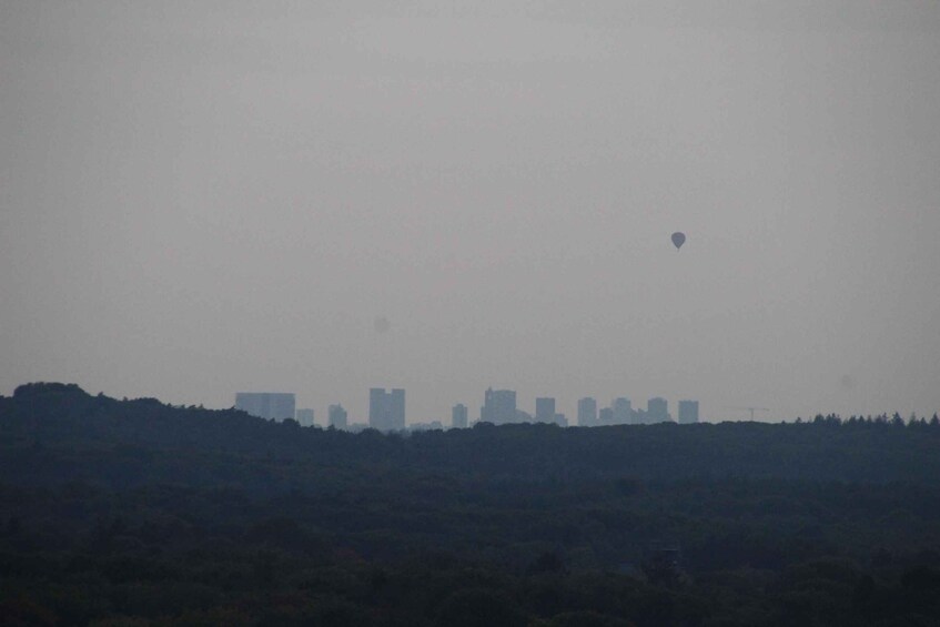 A city skyline with buildings silhouetted against a hazy sky. 3