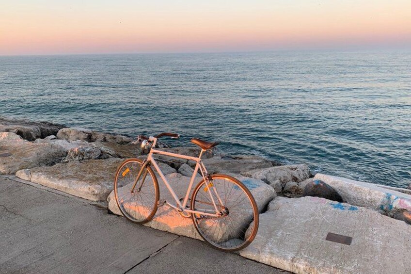 A bicycle parked on a concrete ledge by the sea. 2