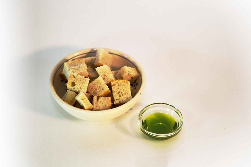 A bowl of croutons and a small glass of green sauce. 2