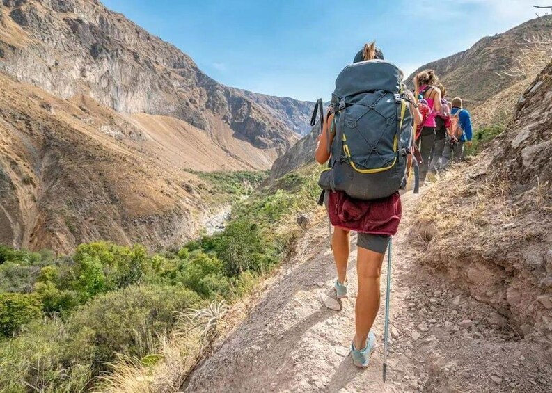A group of hikers ascending a rocky trail in a mountainous area. 1