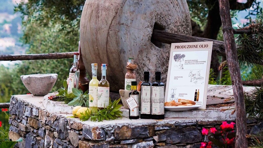 A stone oven, olive oil bottles, and a menu board outdoors. 3