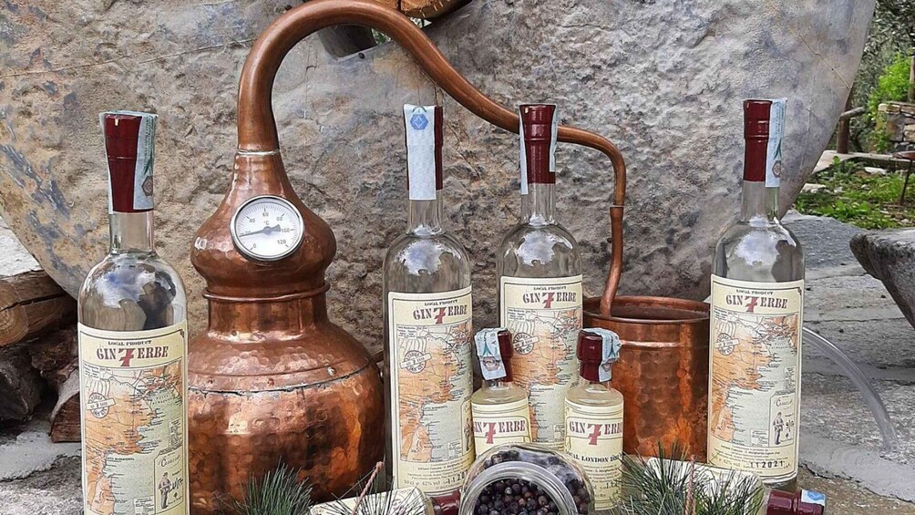 A copper still with bottles of gin and a thermometer. 2