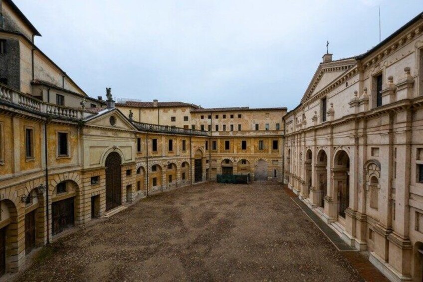 A courtyard with classical architecture, including arched doorways and columns. 2