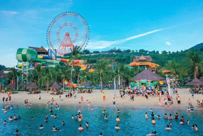 A water park with a large Ferris wheel, palm trees, and a beach area with people swimming and relaxing. 3