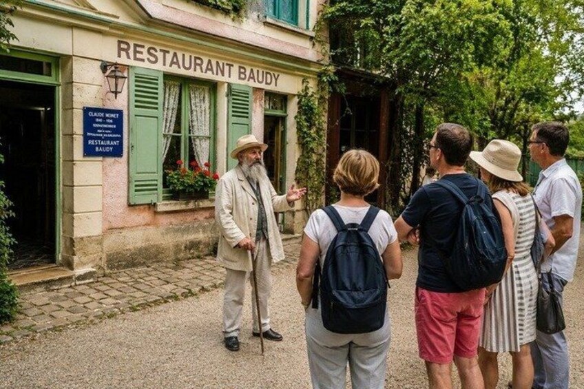 A group of people standing in front of a restaurant named 'RESTAURANT BAUDY'. 1
