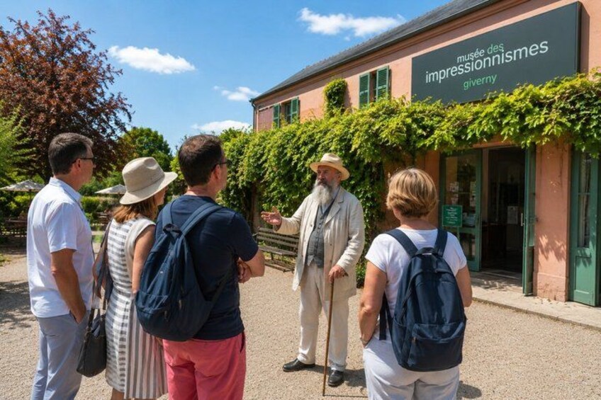 A group of people standing in front of a museum with a sign that reads 'musée des impressionnismes'. 5