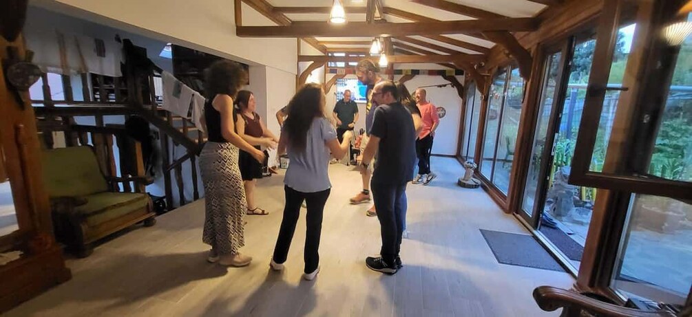 A group of people in a room with wooden beams and large windows. 5