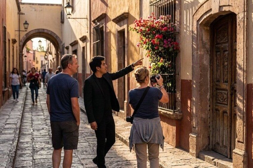A narrow street with cobblestone pavement, historic buildings, and a person pointing at a window with flowers. 3