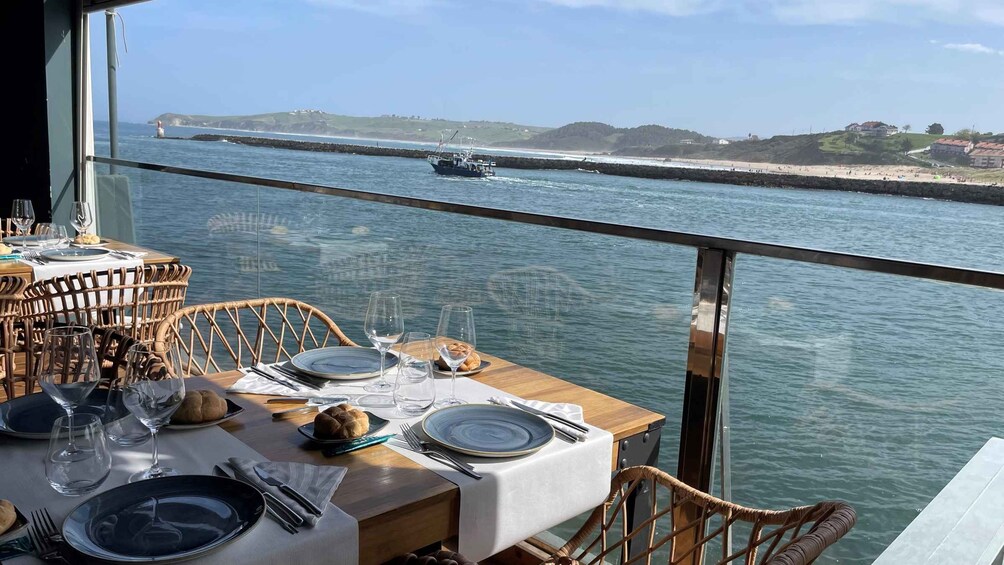 A table set for dining with a view of the sea and a distant boat. 3
