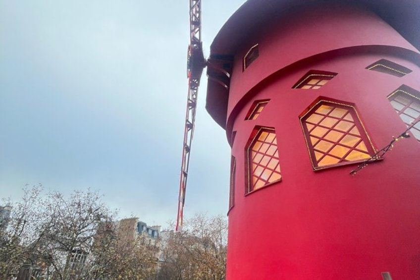 A red cylindrical structure with windows, a crane, and trees in the foreground. 5