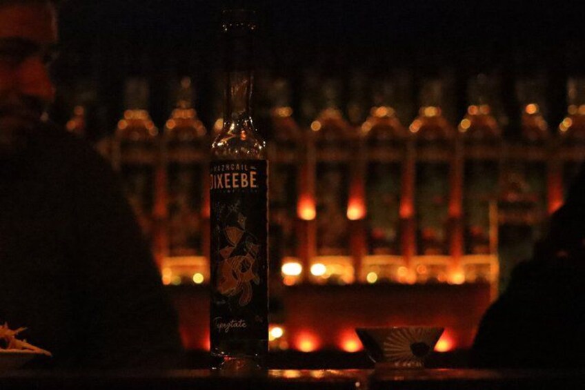 A bottle of Jim Beam whiskey on a bar counter with a blurred background of bottles and lights. 5