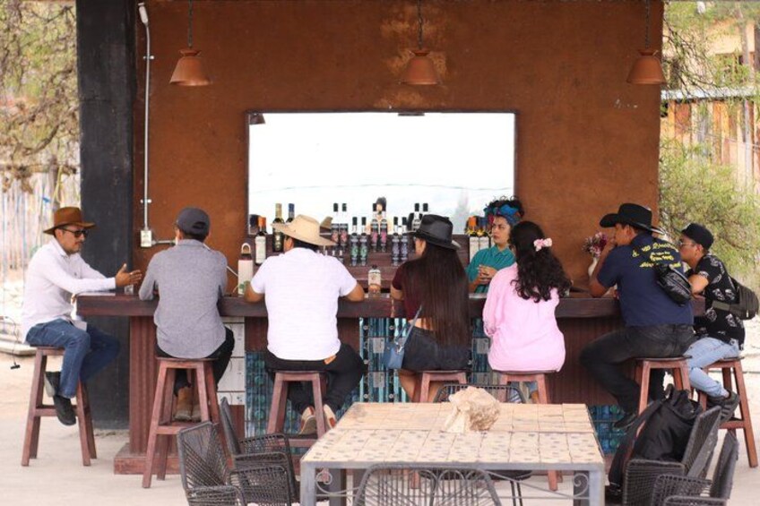 A bar with stools and a table, surrounded by chairs. 4