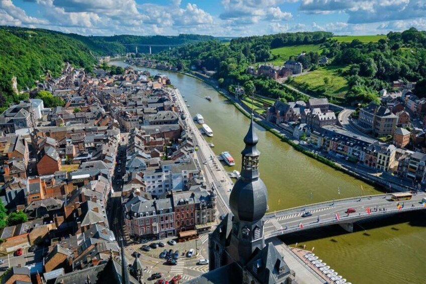 A river flowing through a town with historic buildings, a prominent tower, and a bridge. 4
