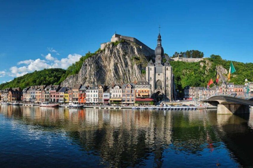 A river with a bridge, colorful buildings, a church, and a castle on a hill. 2