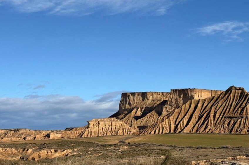 A vast landscape with prominent rock formations and a clear blue sky. 3