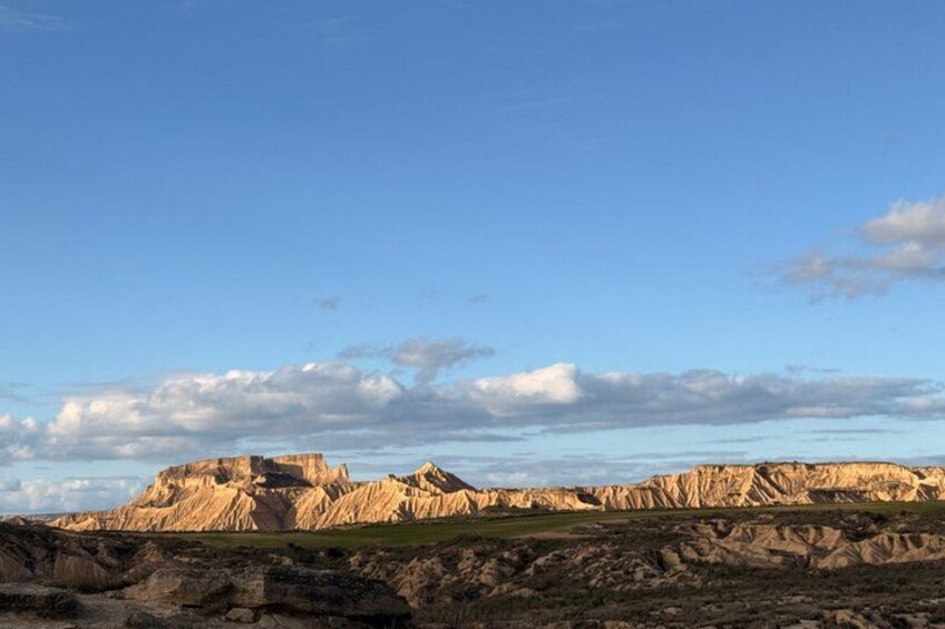 A rugged landscape with layered rock formations under a clear sky. 4