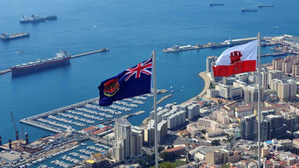Una ciudad costera con un puerto deportivo, barcos y dos banderas. 4
