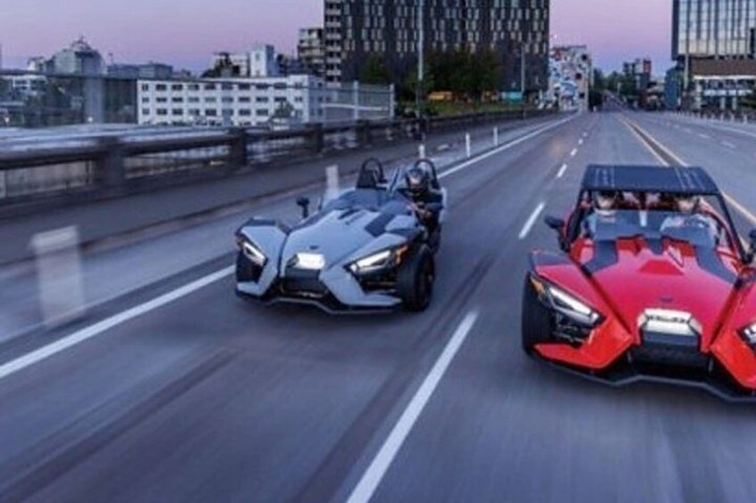 To futuristiske biler kører på en motorvej i skumringen. 2