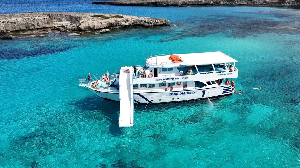 A boat named 'Blue Diamond Boat Trips' anchored in clear turquoise waters. 1