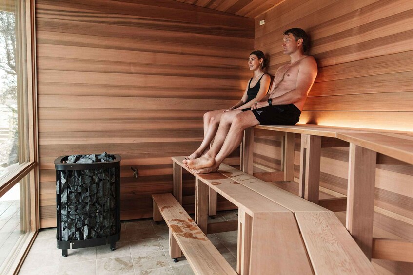 A sauna with wooden benches and a stone heater. 5