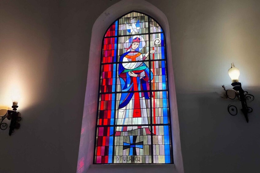 A stained glass window with a religious figure, a cross, and the word 'STULICH.' 4
