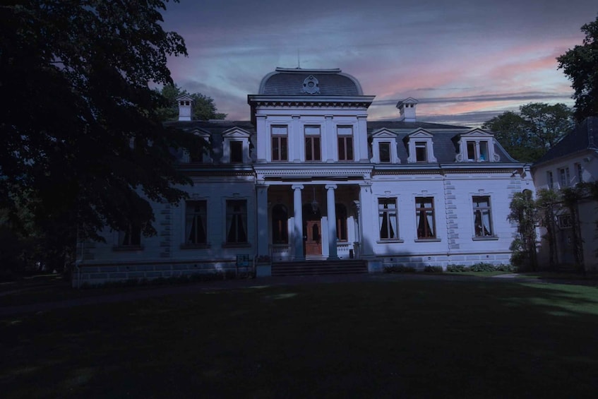 A large, white, classical-style mansion with a symmetrical facade, columns, and a central entrance. 1