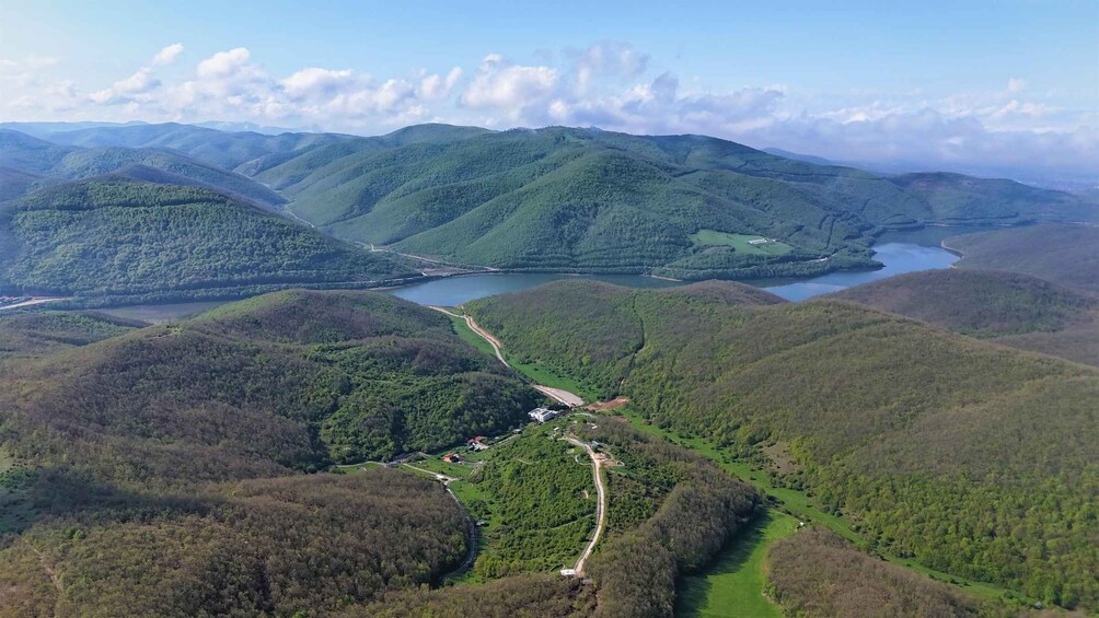 Eine gebirgige Landschaft mit einem Fluss, grünen Tälern und einer Straße. 5