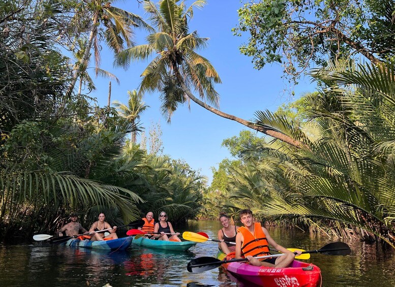 People kayaking on a river surrounded by palm trees. 1
