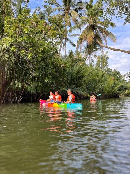 People kayaking on a river surrounded by dense tropical vegetation. 4