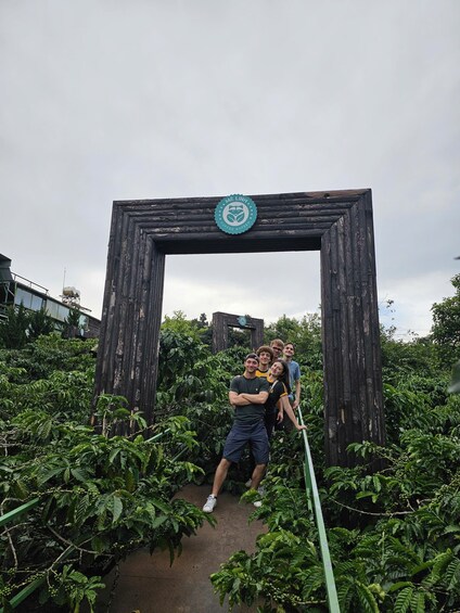 A group of people posing in front of a wooden archway with a logo. 5