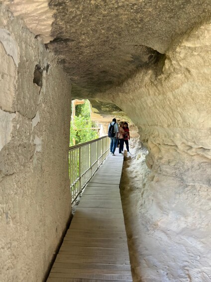 A wooden walkway in a cave with people walking. 2
