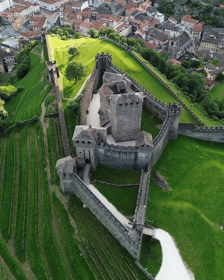 An aerial view of a historic castle surrounded by a moat and lush green fields. 3