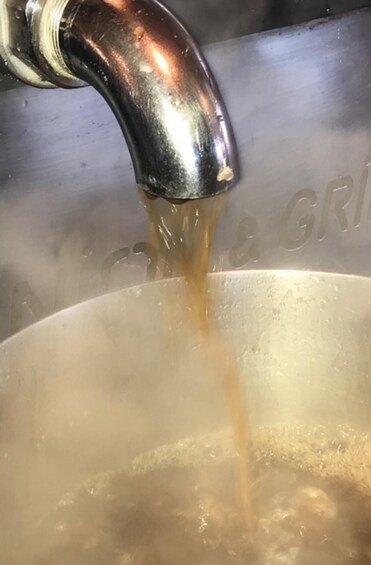 A metallic faucet pouring water into a pot. 2